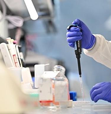 Scientist injects material into a test tube